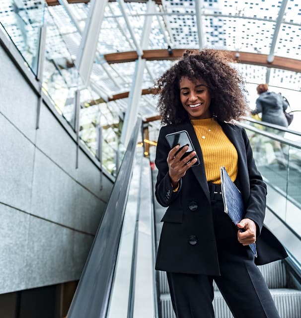 woman on escalator looking at phone