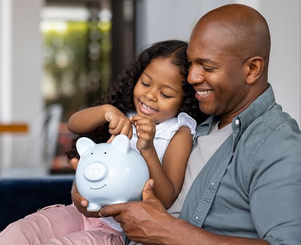 Father and Daughter holding a piggy bank